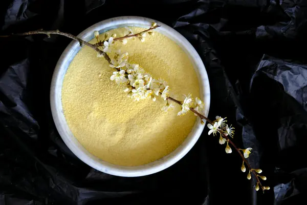Alioli cremoso en un cuenco blanco con ajos y hierbas frescas