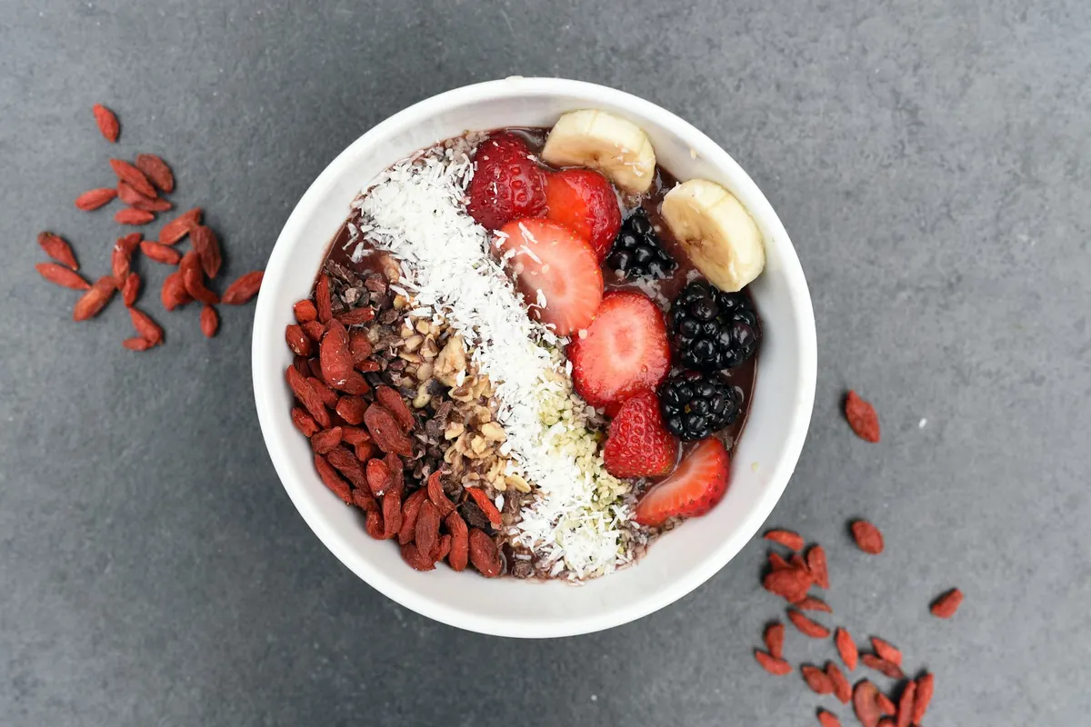 Avena nocturna con plátano, frutos rojos y granola en un bol