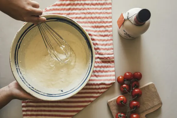 Mayonesa casera batida a mano en un bol con huevo y aceite