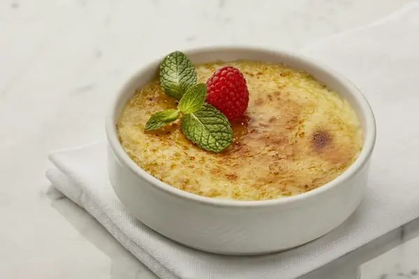 Natillas caseras cremosas en un cuenco con una fresa