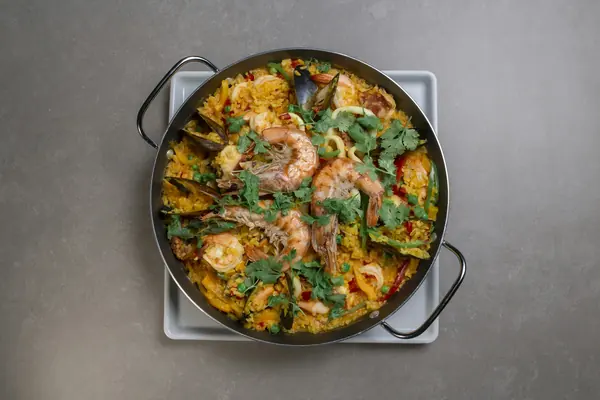 Paella valenciana de arroz con mariscos en una paella ancha