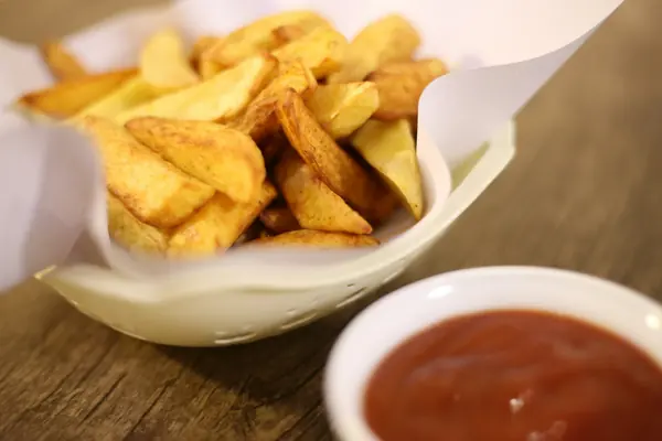 Patatas bravas doradas con salsa brava en un cuenco