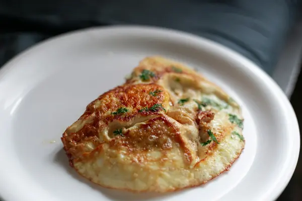Tortilla de patatas española recién hecha y dorada en un plato blanco